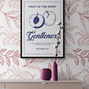 May include: A white poster with a blue and red design. The poster features a fruit illustration and the text "FRUIT OF THE SPIRIT Gentleness A GENTLE ANSWER TURNS AWAY WRATH, BUT A HARSH WORD STIRS UP ANGER. PROVERBS 15:1".