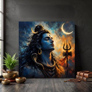 May include: A square wall art print depicting a blue-skinned deity with long dark hair, a crescent moon, and a snake around the neck. The figure has a third eye mark on the forehead and holds a trident. The background features a vibrant, abstract blend of blue, orange, and yellow colors.