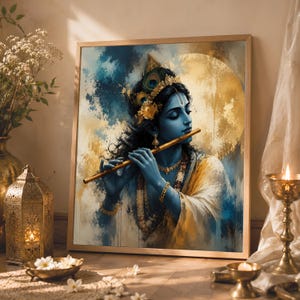 May include: A framed wall art print depicting a blue-skinned figure with a peacock feather in their hair, playing a wooden flute. The figure is adorned with gold jewellery against a textured background of swirling blue and golden yellow paint strokes.