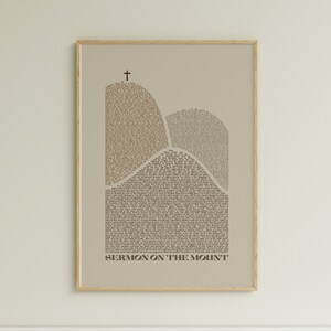May include: A beige poster with a brown outline of two mountains, formed by the text of the Sermon on the Mount. The text is in a serif font and the title "Sermon on the Mount" is at the bottom of the poster.