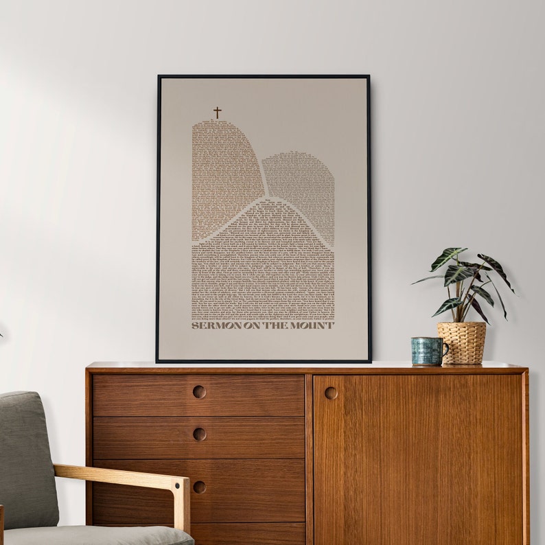 May include: A black framed print with a beige background featuring a stylized image of two mountains with the text "SERMON ON THE MOUNT" at the bottom.