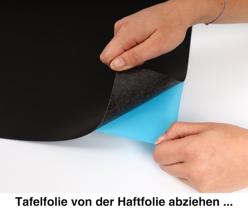 May include: A hand peeling back a black chalkboard sticker from a blue adhesive backing. The text "Tafelfolie von der Haftfolie abziehen..." is visible at the bottom of the image.