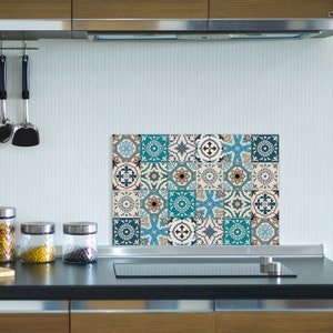 Puede incluir: Un salpicadero de azulejos azules y blancos para una cocina. Los azulejos están dispuestos en un patrón de mosaico y presentan formas geométricas y diseños florales.