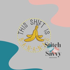 May include: Embroidered design featuring a yellow banana peel with the text "THIS SHIFT IS BANANAS" in a circular pattern. The design includes the text "Stitch Savvy Designs" with spools of thread.