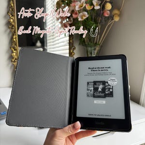 Pode incluir: Um leitor de e-books Kindle preto com uma capa cinza. A tela exibe uma capa de livro com o t&iacute;tulo "familiar" e o texto "Read or do not read. There is no try." O texto "Browse the Amazon Editors' best science fiction and fantasy books of 2024" tamb&eacute;m &eacute; exibido na tela.