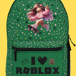 May include: Green backpack with a cartoon girl on a skateboard, pink stars, and the text "I love ROBLOX" with a video game controller and a heart.