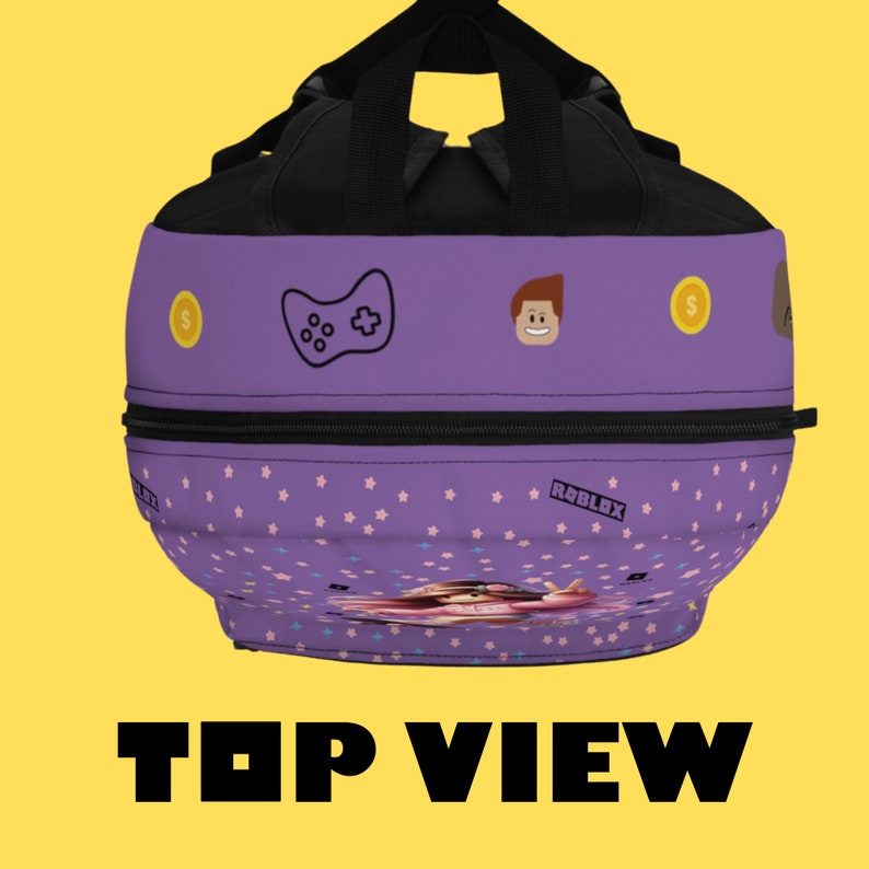 May include: Purple and black backpack with a gamer theme. It features a video game controller, a Roblox logo, and a cartoon character. The backpack has a zippered pocket and a small pocket on the front.