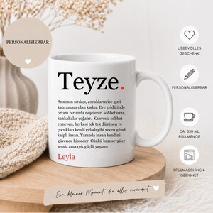 Könnte beinhalten: Weiße Keramik-Tasse mit dem türkischen Wort "Teyze" in großen schwarzen Buchstaben und einem roten Punkt. Die Tasse hat einen Henkel und Text auf Türkisch. Die Tasse steht auf einer Holzoberfläche.