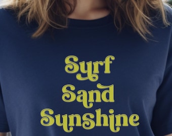 Camiseta Surf Sand Sunshine, estilo retro con letras amarillas, ideal para vacaciones o verano.
