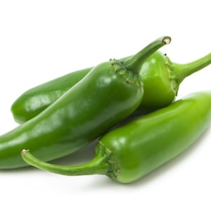 Puede incluir: Tres chiles jalapeños verdes, dos de los cuales están enteros y uno está parcialmente cortado, están dispuestos sobre un fondo blanco.