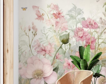 以下が含まれることがあります： ピンクの花と緑の葉が描かれた水彩画のフラワーウォールペーパーの壁画。壁画の前に、薄い茶色のクッションが付いた籐製の椅子が置かれている。椅子の右側には、緑の葉の入った鉢植えの植物がある。