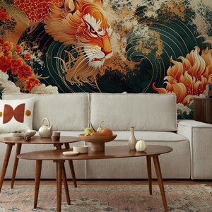 K&ouml;nnte beinhalten: Ein wei&szlig;es Sofa mit einem gemusterten Kissen steht vor einer Wandmalerei mit einem roten und goldenen Drachen, der aus einer Welle aufsteigt. Die Wandmalerei zeigt auch rote und goldene Blumen. Zwei Holz-Couchtische stehen vor dem Sofa, und eine runde, geflochtene Kugel liegt auf dem Boden.