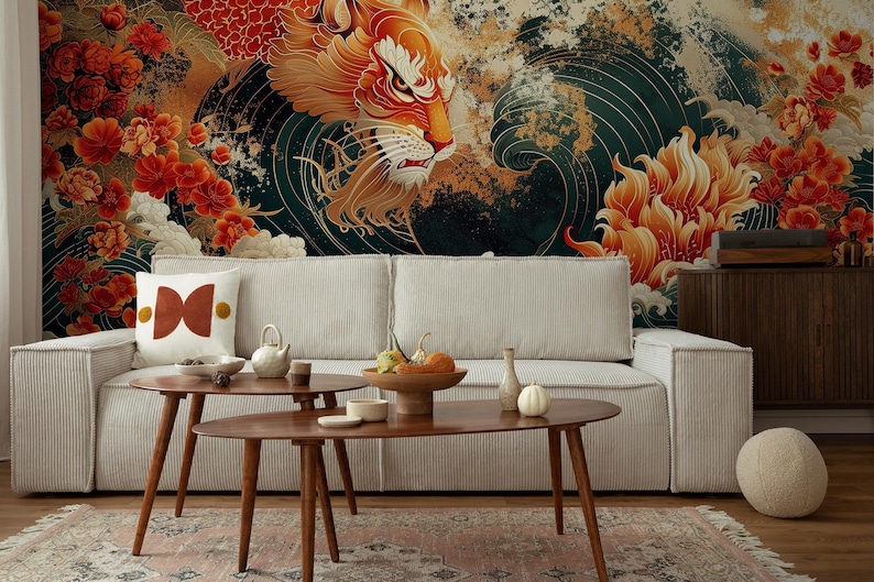 K&ouml;nnte beinhalten: Ein wei&szlig;es Sofa mit einem gemusterten Kissen steht vor einer Wandmalerei mit einem roten und goldenen Drachen, der aus einer Welle aufsteigt. Die Wandmalerei zeigt auch rote und goldene Blumen. Zwei Holz-Couchtische stehen vor dem Sofa, und eine runde, geflochtene Kugel liegt auf dem Boden.