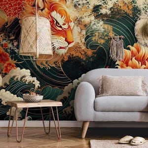 K&ouml;nnte beinhalten: Ein farbenfrohes Wandbild mit einem stilisierten orangefarbenen L&ouml;wen mit Wellenmuster und roten Blumen. Das Wandbild ist in einem Wohnzimmer mit einem grauen Sofa, einem Holz-Beistelltisch und einer gewebten Wolldecke dargestellt.