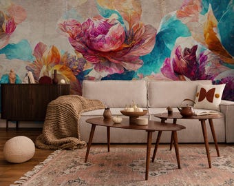 May include: A living room scene featuring a beige sofa, wooden coffee tables, and a patterned rug. The wall is adorned with a large, colorful floral mural in shades of pink, blue, and orange. Decorative items include a knitted throw and a decorative pillow.