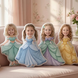 May include: Four custom-shaped throw pillows featuring illustrations of young children with smiling faces superimposed onto the bodies of cartoon princesses wearing teal, blue, green and purple, and yellow gowns with detailed fabric folds.
