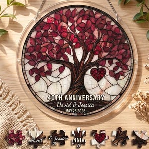 Pode incluir: Decoração redonda de aniversário em acrílico transparente com um design de árvore em vitral. A árvore tem folhas vermelhas e um detalhe em forma de coração. O texto diz "40th Anniversary" com nomes e uma data. Inclui peças de quebra-cabeça.