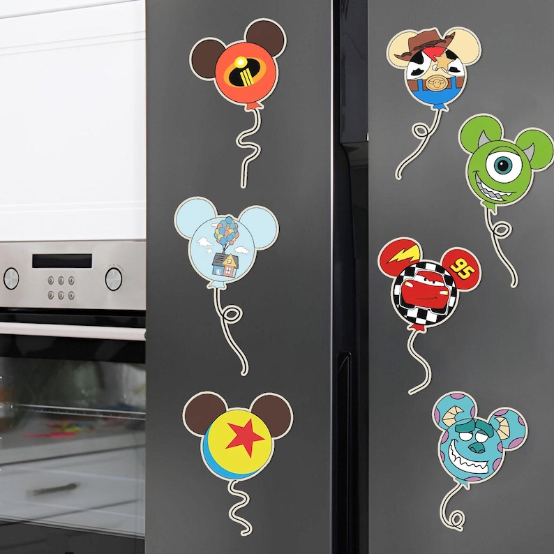 K&ouml;nnte beinhalten: Ein Set mit sechs K&uuml;hlschrankmagneten mit Disney-Charakteren. Jeder Magnet ist in Form von Mickey-Maus-Ohren gestaltet und zeigt einen anderen Charakter, darunter Buzz Lightyear, Sully, Lightning McQueen, Woody und Mike Wazowski.