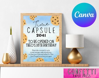 Op de afbeelding: Een lichtblauw en bruin bedrukbaar bord met de tekst "Lime Capsule 2041 To Be Opened On Theo's 18th Birthday" en een cookie-afbeelding. Het bord is ingelijst in een lichtbruin frame en ligt op een houten oppervlak.