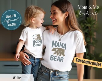 May include: White t-shirts with matching bear graphics. One shirt says "Mama Bear" with a bear illustration, and the other says "Baby Bear." The shirts are part of a "Mom & Me" collection, and are customizable.
