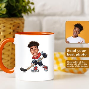 May include: White ceramic mug with an orange handle and rim, featuring a cartoon illustration of a hockey player. The mug has the text "Send your best photo". The quality of the photo will affect the quality of the design.