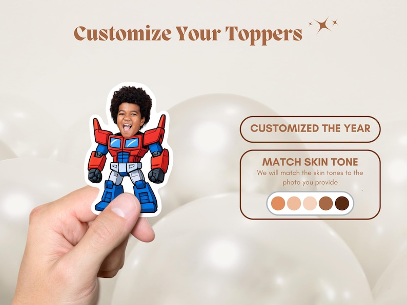 May include: A sticker featuring a child's face integrated into a cartoon robot design, with red, blue, and white accents. The text "Customize Your Toppers" is at the top. The image also includes text that says "CUSTOMIZED THE YEAR" and "MATCH SKIN TONE".