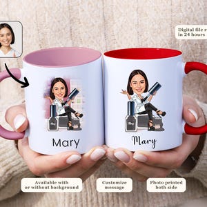 Op de afbeelding: Twee witte keramische mokken met roze en rode randen. Beide mokken hebben een cartoonillustratie van een vrouw met de naam "Mary" eronder gedrukt. De mok aan de linkerkant heeft een roze handvat en de mok aan de rechterkant heeft een rood handvat.