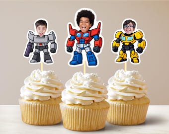May include: Three cupcakes with white frosting and pearl sprinkles. Each cupcake has a different cartoon character topper with a child's face. The characters are robots in red, yellow, and grey.
