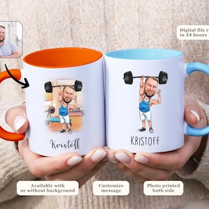 May include: Two white ceramic mugs with custom illustrations of a man lifting weights. One mug has an orange handle and interior, the other has a blue handle and interior. The mugs are personalized with the name "Kristoff".