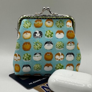 ターコイズブルーの可愛い柴犬プリント生地で手作りされたレトロなキス留め金の小銭入れ。