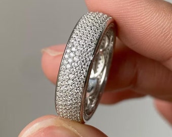 May include: A silver band ring with a pave setting of small diamonds.
