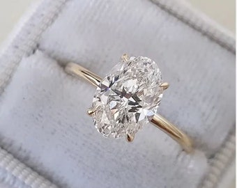 May include: A gold engagement ring with a large oval-shaped diamond.