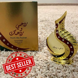 May include: A gold and red perfume bottle with a decorative design. The bottle is labeled "Roohi Wa Roohak Concentrated Perfume Oil 20ml".