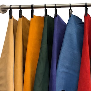 May include: Eight different coloured leather swatches hanging on a silver metal rod. The swatches are in the following order: tan, light brown, orange, dark green, blue, red, and brown.