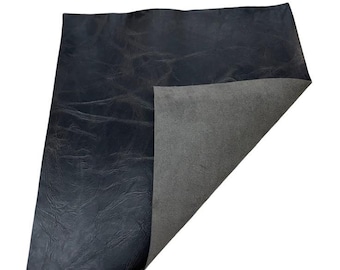 Op de afbeelding: Een donkerblauw lederen vel met een gestructureerd oppervlak. Het vel is omgeslagen om een ​​grijze achterkant te laten zien.