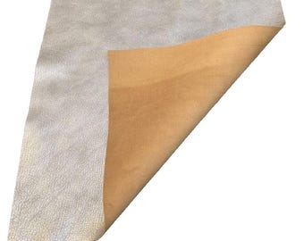 May include: A piece of light brown suede fabric with a white backing. The suede is folded over to show the white backing.