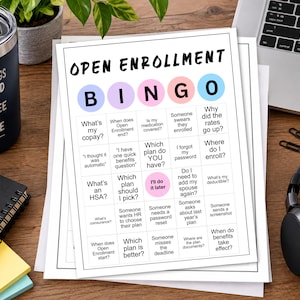 May include: A white paper sheet featuring an Open Enrollment Bingo game with a grid of text prompts in black ink. The header BINGO is displayed in colorful circles. The game includes phrases like What's my copay, I'll do it later, and Where do I enroll.