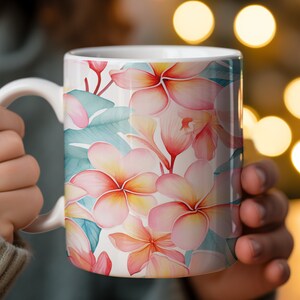 May include: White ceramic mug with a floral design featuring pink and yellow flowers with green leaves.