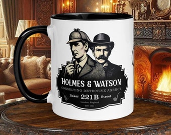 May include: A white ceramic mug with a black handle and black rim. The mug features a black and white illustration of Sherlock Holmes and Dr. Watson with the text "Holmes & Watson Consulting Detective Agency Baker Street 221B London, England 1887."
