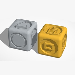 May include: Two 3D-printed dice. One is grey with a circle, triangle, and square. The other is yellow with a series of rectangular shapes. The dice are on a white surface.