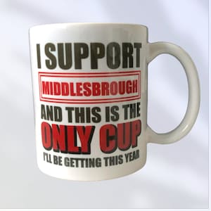 May include: White ceramic mug with a black and red design. The mug says "I support Middlesbrough and this is the only cup I'll be getting this year."