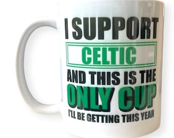 May include: White ceramic mug with a black and green design. The mug says "I support Celtic and this is the only cup I'll be getting this year."