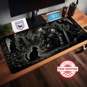 May include: Black and white mousepad featuring a knight kneeling before a cat in a medieval setting. The mousepad has a detailed illustration with a sword and stone archways. The "Whisker Wolves" logo is visible on a card.