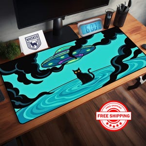 May include: A rectangular mousepad featuring a teal background with a cartoon scene. A black cat with glowing yellow eyes sits in water, with a UFO above. Black smoke billows around the UFO. The mousepad has a black border.