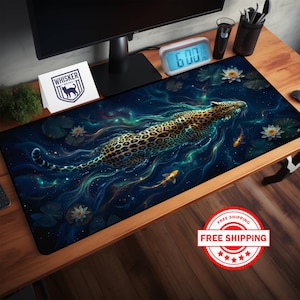 May include: A rectangular desk mat featuring a jaguar swimming in a cosmic, water-like environment. The design includes lily pads, koi fish, and a starry background. The mat has the "Whisker" logo in the upper left corner.