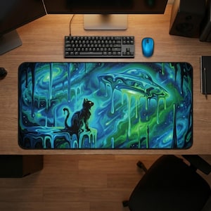 May include: A rectangular desk mat featuring a vibrant, surreal space scene with a black cat silhouette sitting on a ledge. The artwork displays a melting, dripping effect in shades of neon green and deep blue, with a flying saucer hovering above.