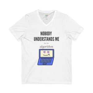 May include: A white V-neck t-shirt featuring the black text NOBODY UNDERSTANDS ME like the algorithm above a graphic of a blue laptop with a smiling face and purple heart-shaped eyes on the screen, centered on the chest of the garment.
