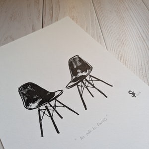 Peut inclure: Dessin au trait noir et blanc de deux chaises Eames sur fond blanc. Le dessin est intitulé "An ode to Eames".