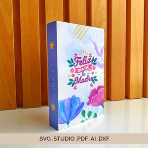Może przedstawiać: Szablon pudełka w kształcie książki z wzorem kwiatów i tekstem "Feliz Día de la Madre" (Wesołego Dnia Matki). Szablon jest dostępny w formatach SVG, STUDIO, PDF, AI i DXF.