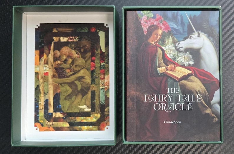 May include: An open green box with a deck of cards and a guidebook. The deck of cards features a collage of figures and foliage. The guidebook cover displays a woman, a unicorn, and the text "THE FAIRY TALE ORACLE".